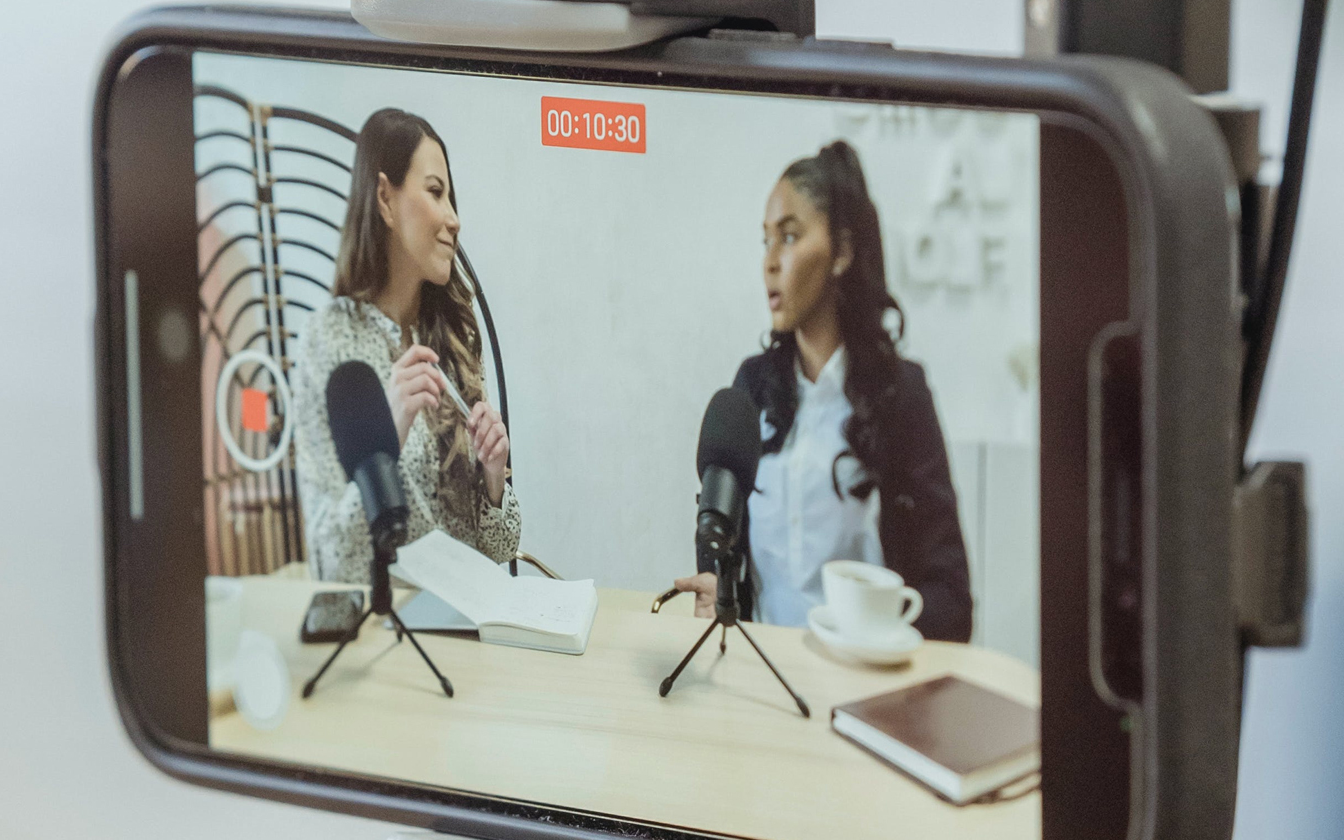 Camera filming two people with microphones