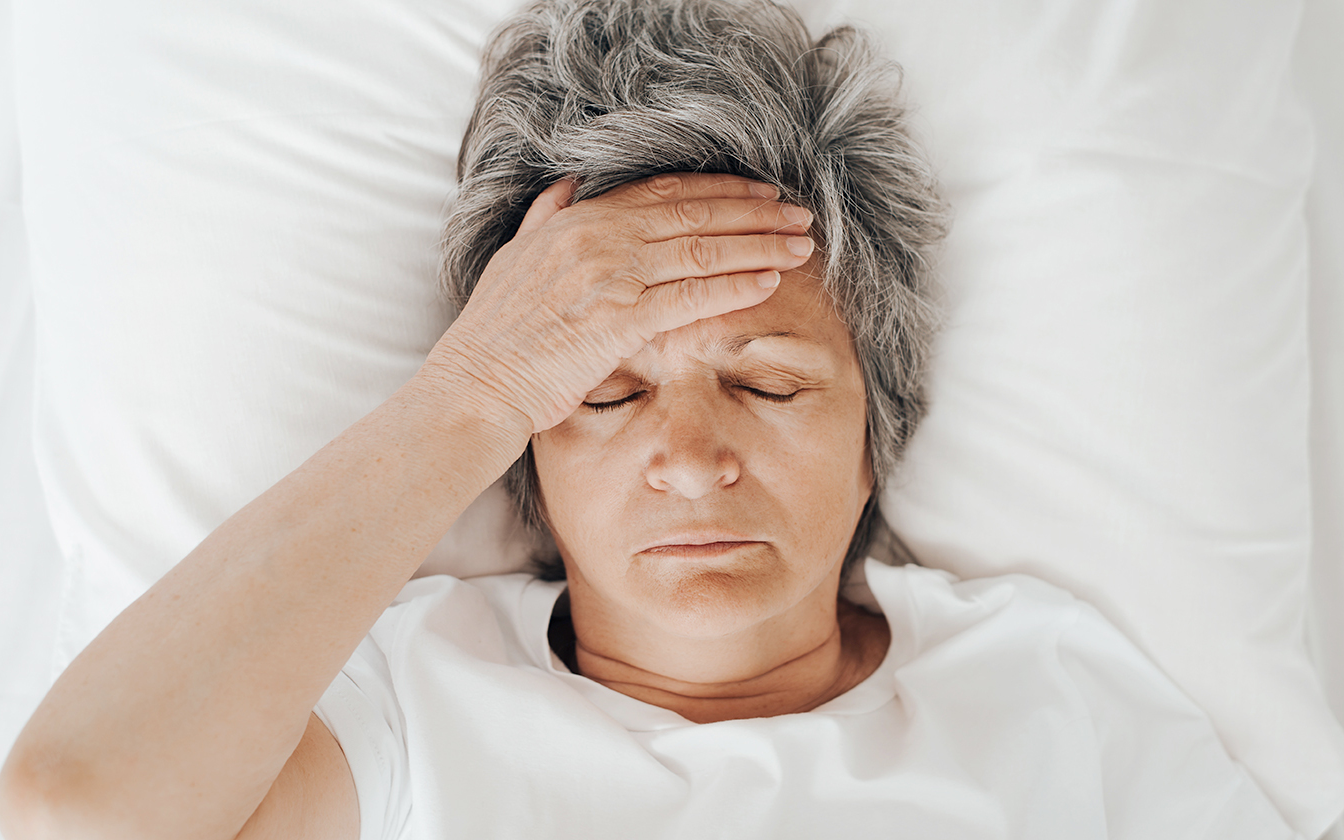 Women in bed holding head